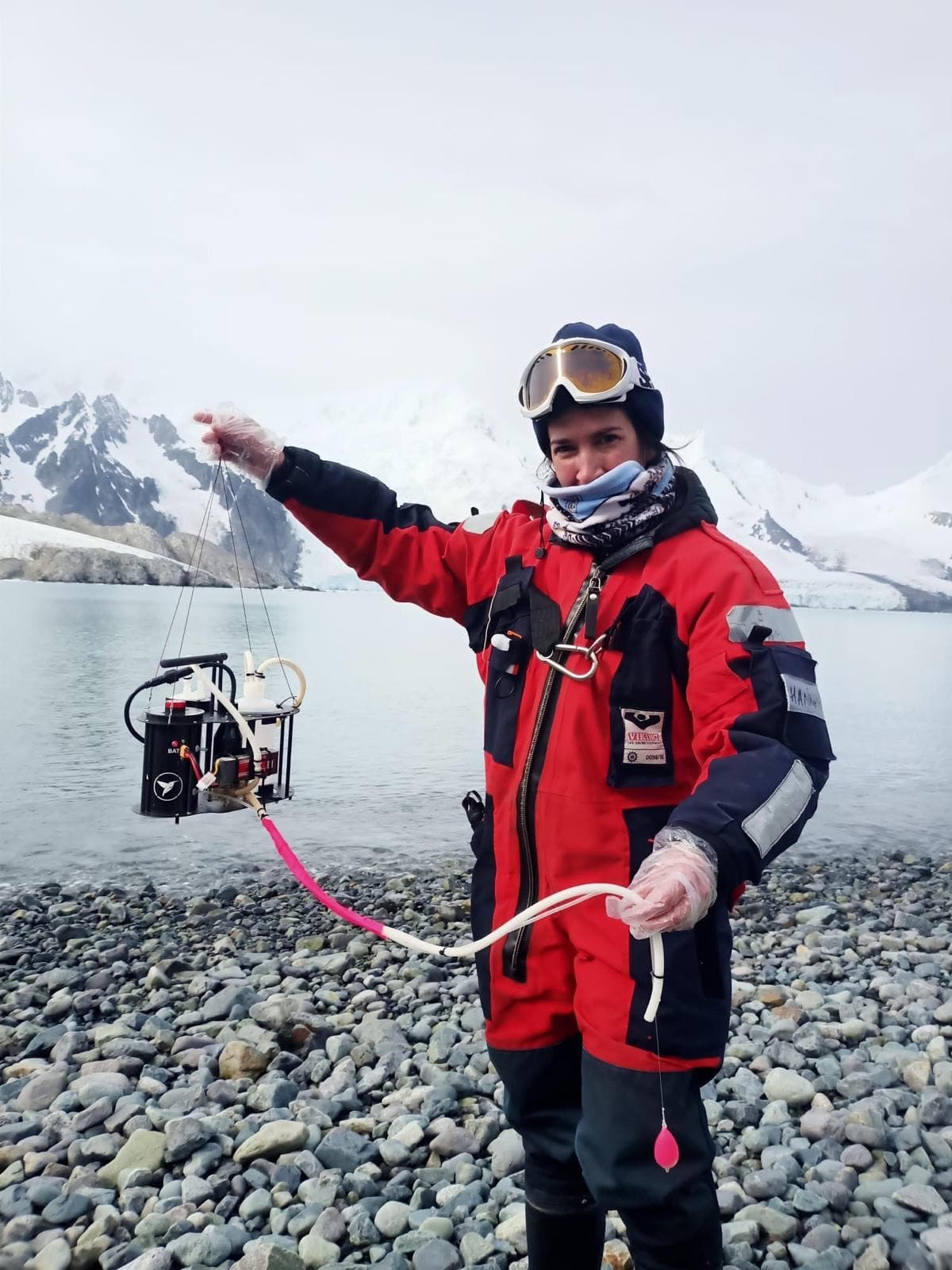 Holding a water sampler in front of an Antarctic glacier